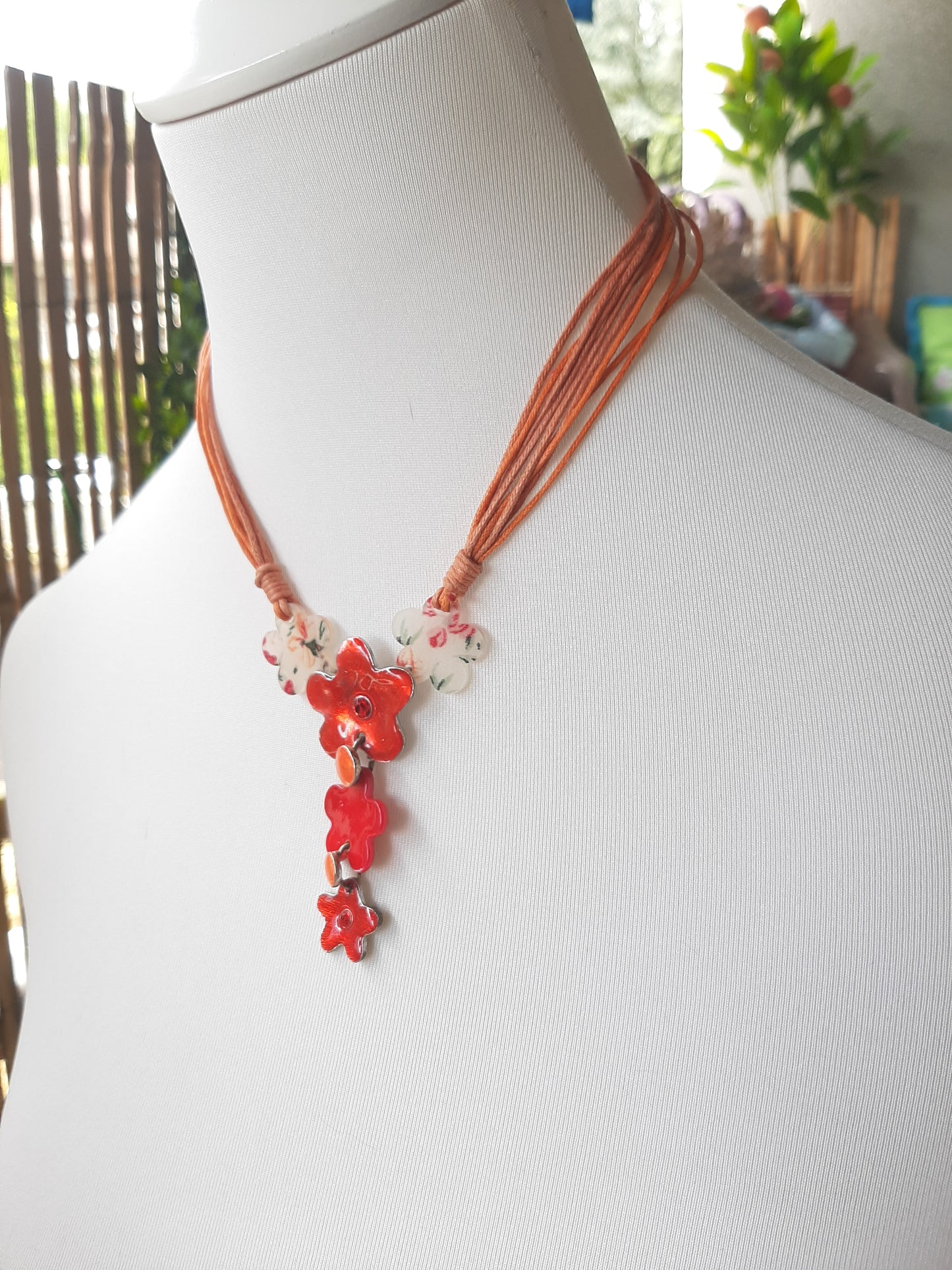 Collier orange et ses fleurs rouges