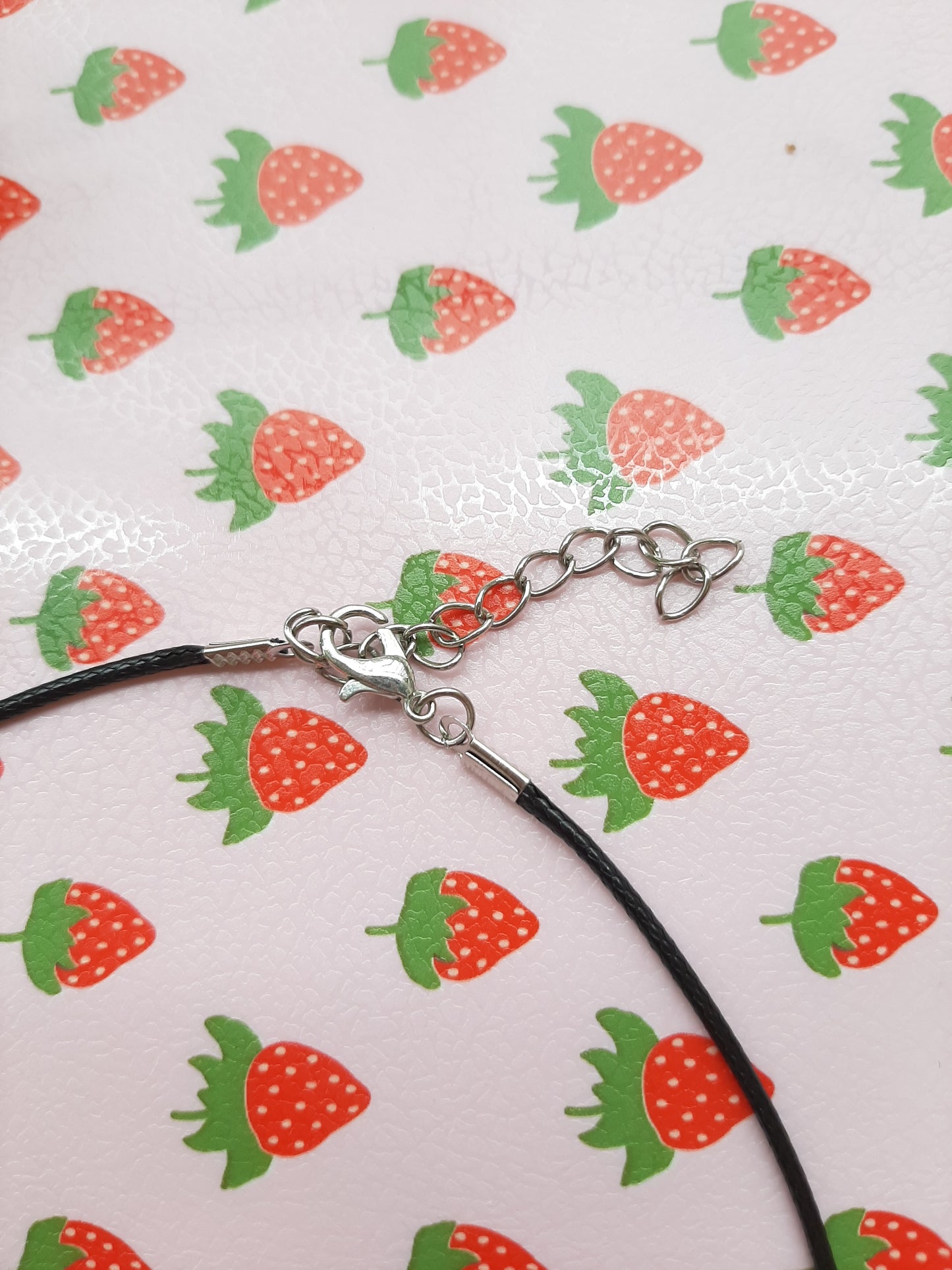 Collier cordon noir avec une fleur et un cœur rouge